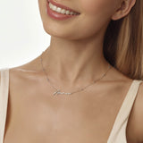 Woman wearing a gold necklace with 'Anna' engraved on it against a neutral background