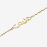 Gold bracelet with Arabic script on a white background