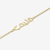 Gold bracelet with Arabic script on a white background
