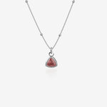 Silver Necklace with a red birthstone pendant on a white background