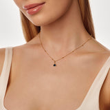 Gold necklace with a birthstone pendant on a model against a neutral background
