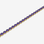 Gold bracelet with purple gemstones on a white background
