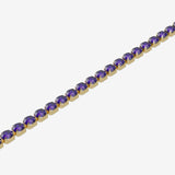 Gold bracelet with purple gemstones on a white background