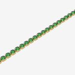 Gold bracelet with green gemstones on a white background