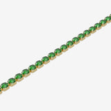 Gold bracelet with green gemstones on a white background