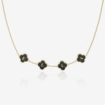 Gold necklace with black clover-shaped pendants on a white background
