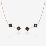 Gold necklace with black clover-shaped pendants on a white background
