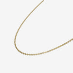 Gold chain necklace on a light beige background