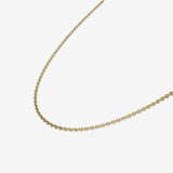 Gold chain necklace on a light beige background