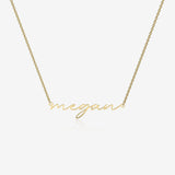Gold necklace with 'megan' pendant on a white background
