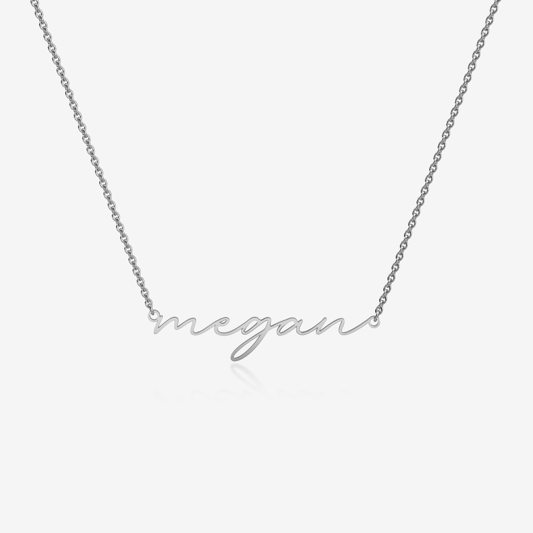 Silver necklace with 'megan' pendant on a white background
