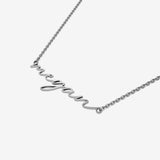 Silver necklace with 'megan' pendant on a white background