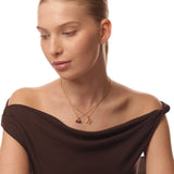 Woman wearing a gold necklace with two pendants on a white background