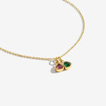 Gold necklace with two teardrop-shaped gemstones on a white background