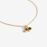 Gold necklace with two teardrop-shaped gemstones on a white background
