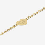 Gold bracelet with a heart-shaped tag with engraving on a white background