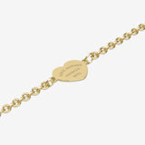 Gold bracelet with a heart-shaped tag with engraving on a white background