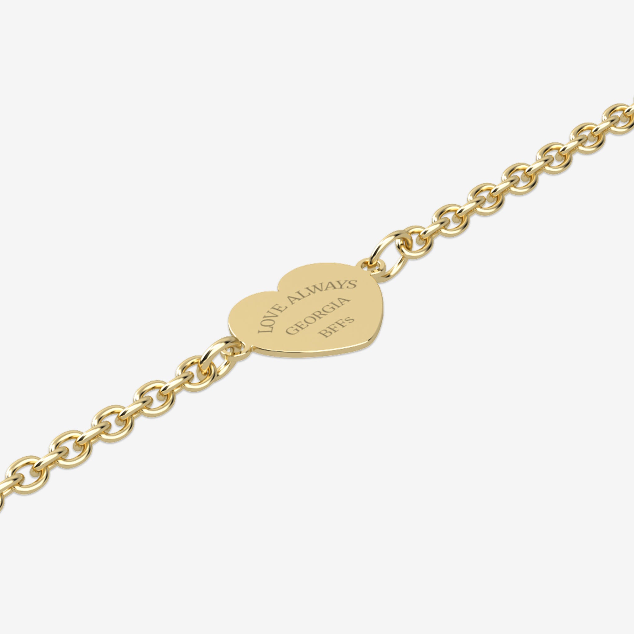 Gold bracelet with a heart-shaped tag with engraving on a white background