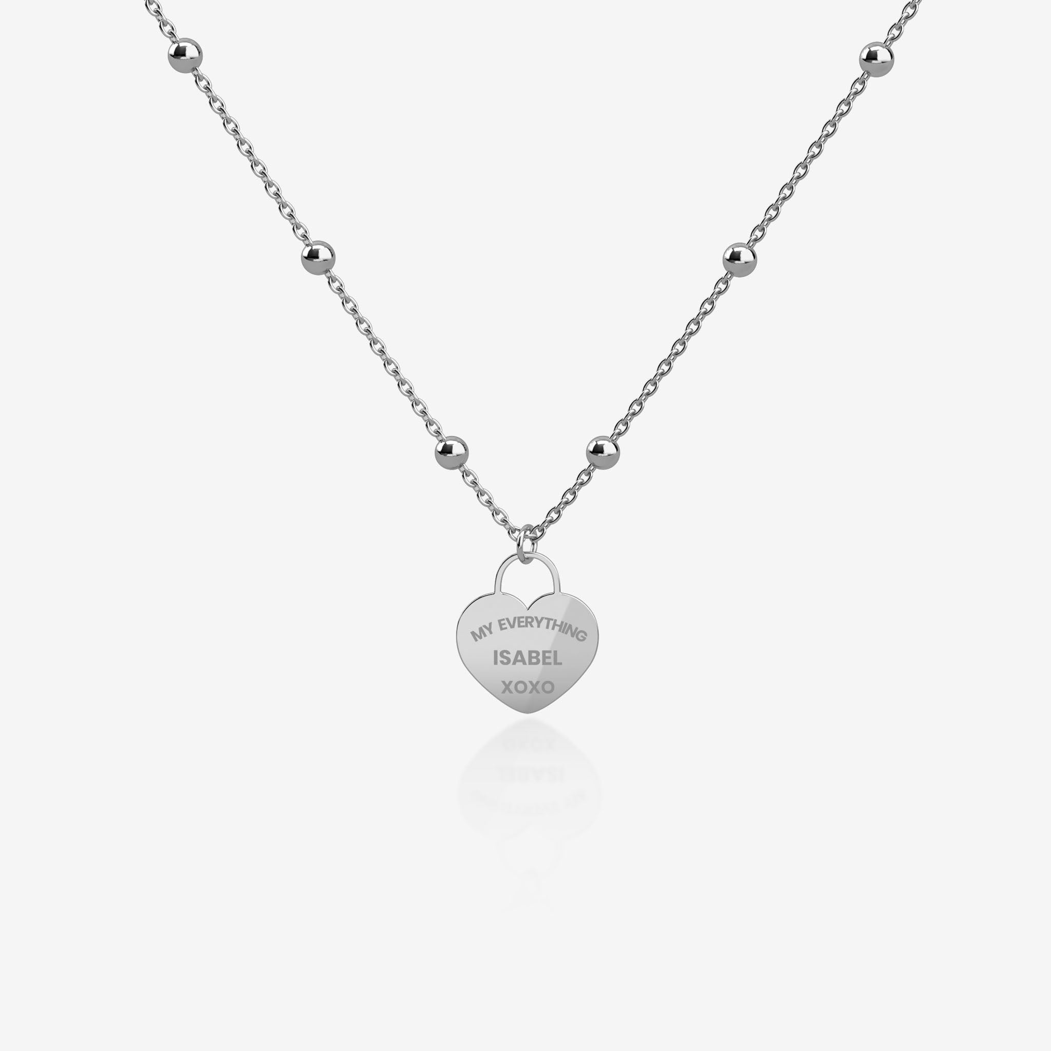 Silver necklace with a heart-shaped pendant with engraving on a white background