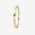 Gold bangle with embedded diamonds on a light beige background