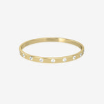 Gold bangle with embedded crystals on a white background