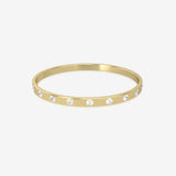 Gold bangle with embedded crystals on a white background