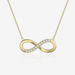 Gold infinity necklace with diamonds on a light beige background