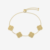 Gold bracelet with clover-shaped charms displaying initials on a white background
