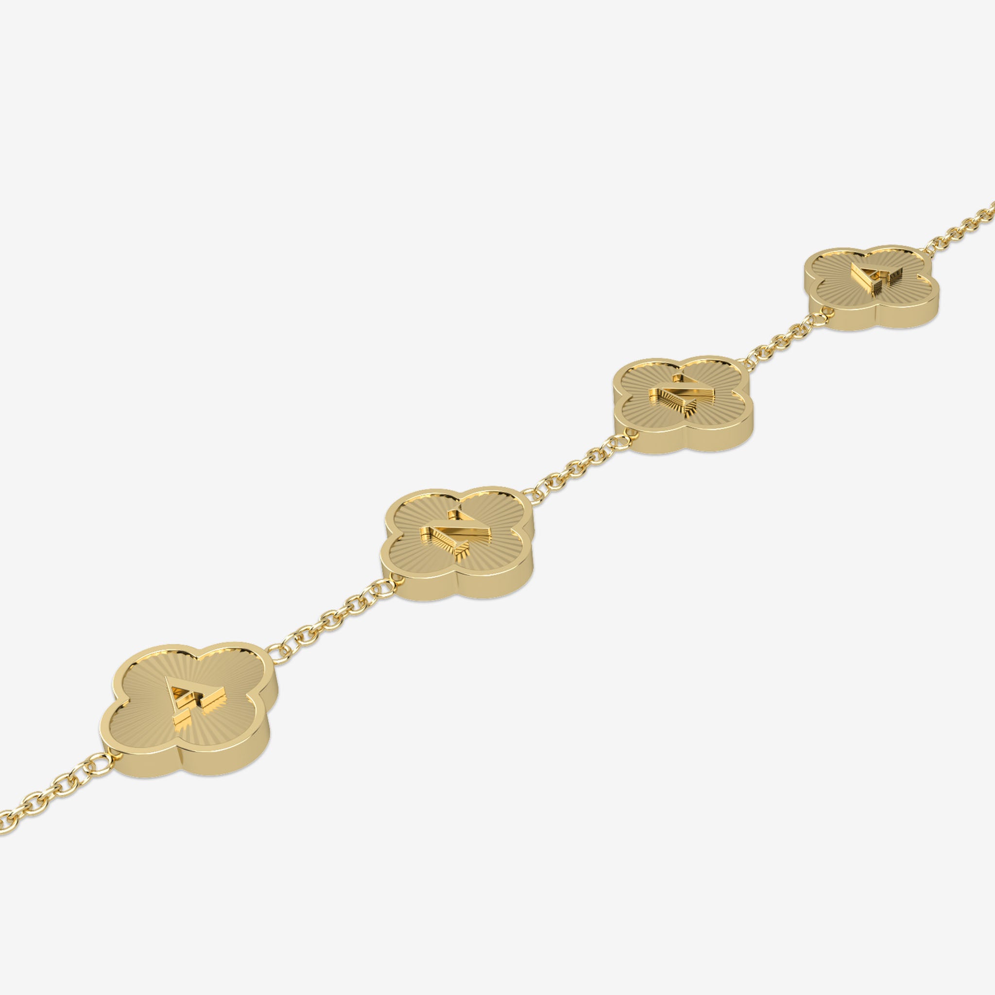 Gold necklace with clover-shaped pendants displaying initials on a white background