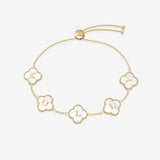 Gold bracelet with clover-shaped charms displays initials on a white background