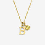 Gold necklace with 'B' pendant and heart-shaped charm on a white background