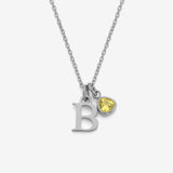 Necklace with a silver 'B' pendant and yellow gemstone on a white background