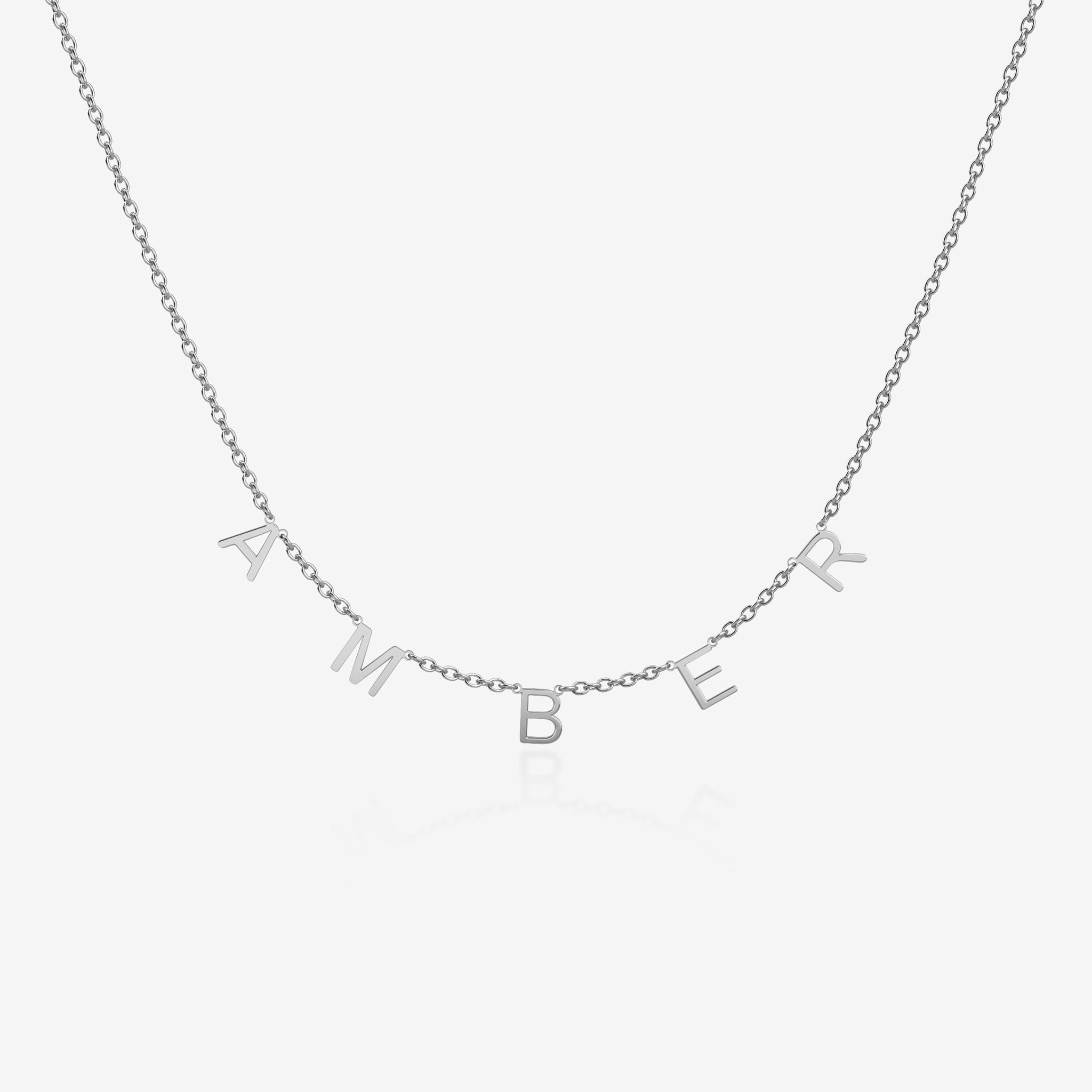 Silver necklace with 'AMBER' initials spread across the chain on a light gray background