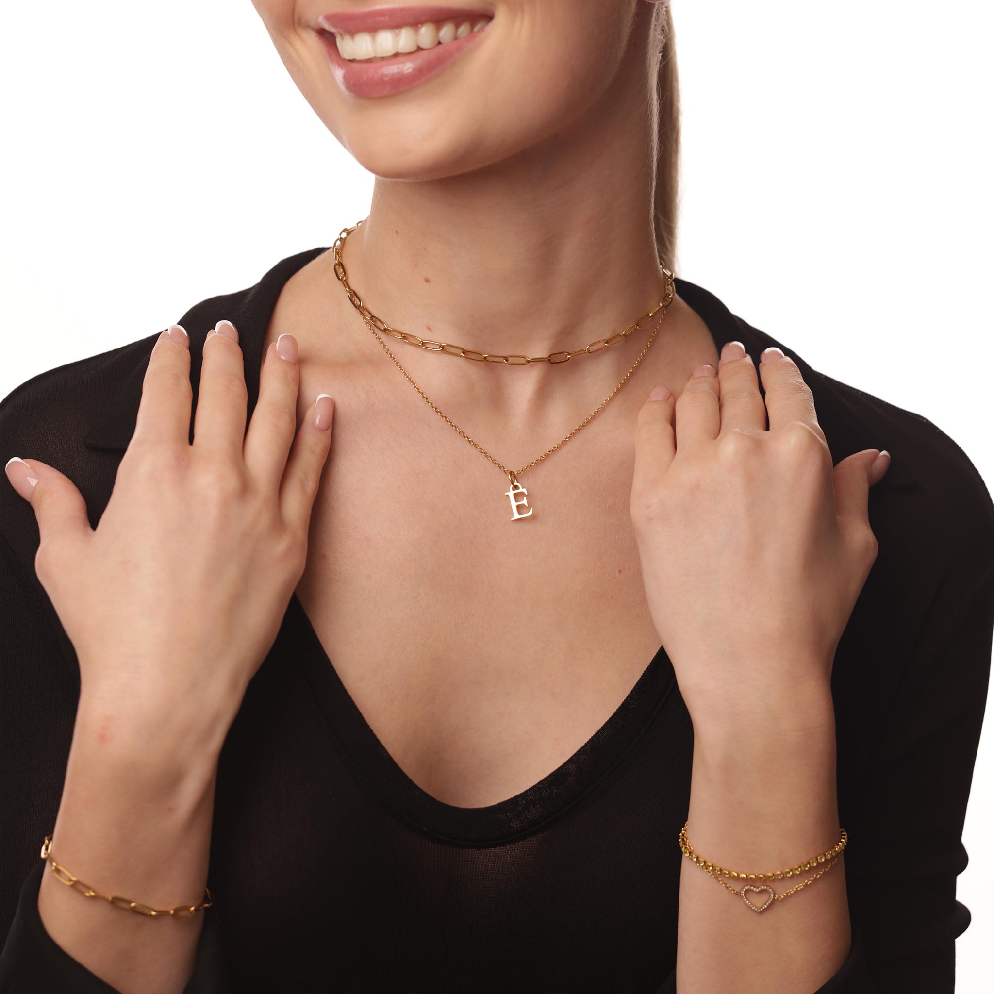 Woman wearing gold necklaces and bracelets on a white background