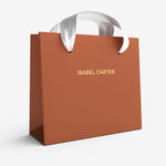 Brown gift bag with 'Isabel Carter' branding on a white background