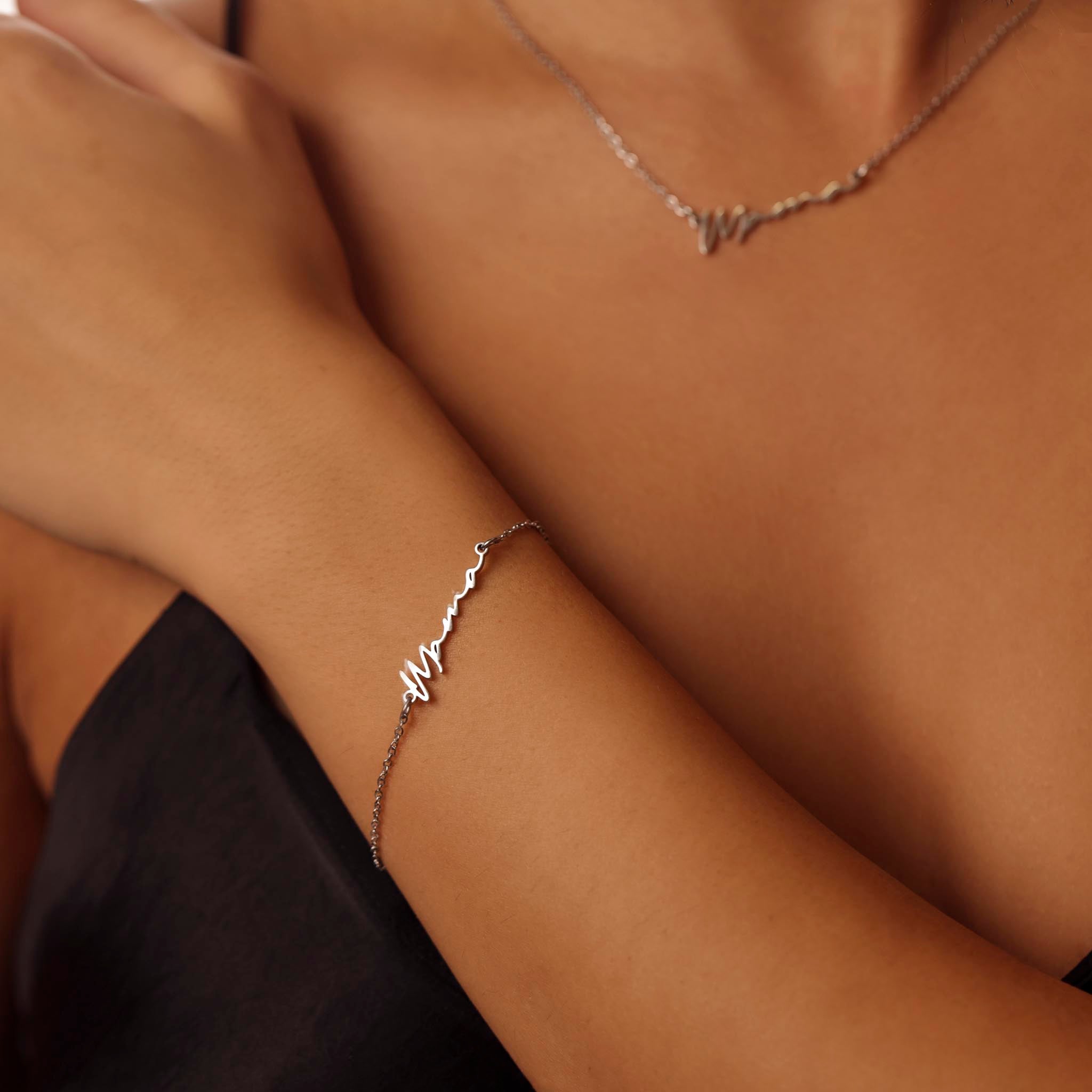 Close-up of a person's arm wearing a delicate mama silver bracelet with a subtle design.