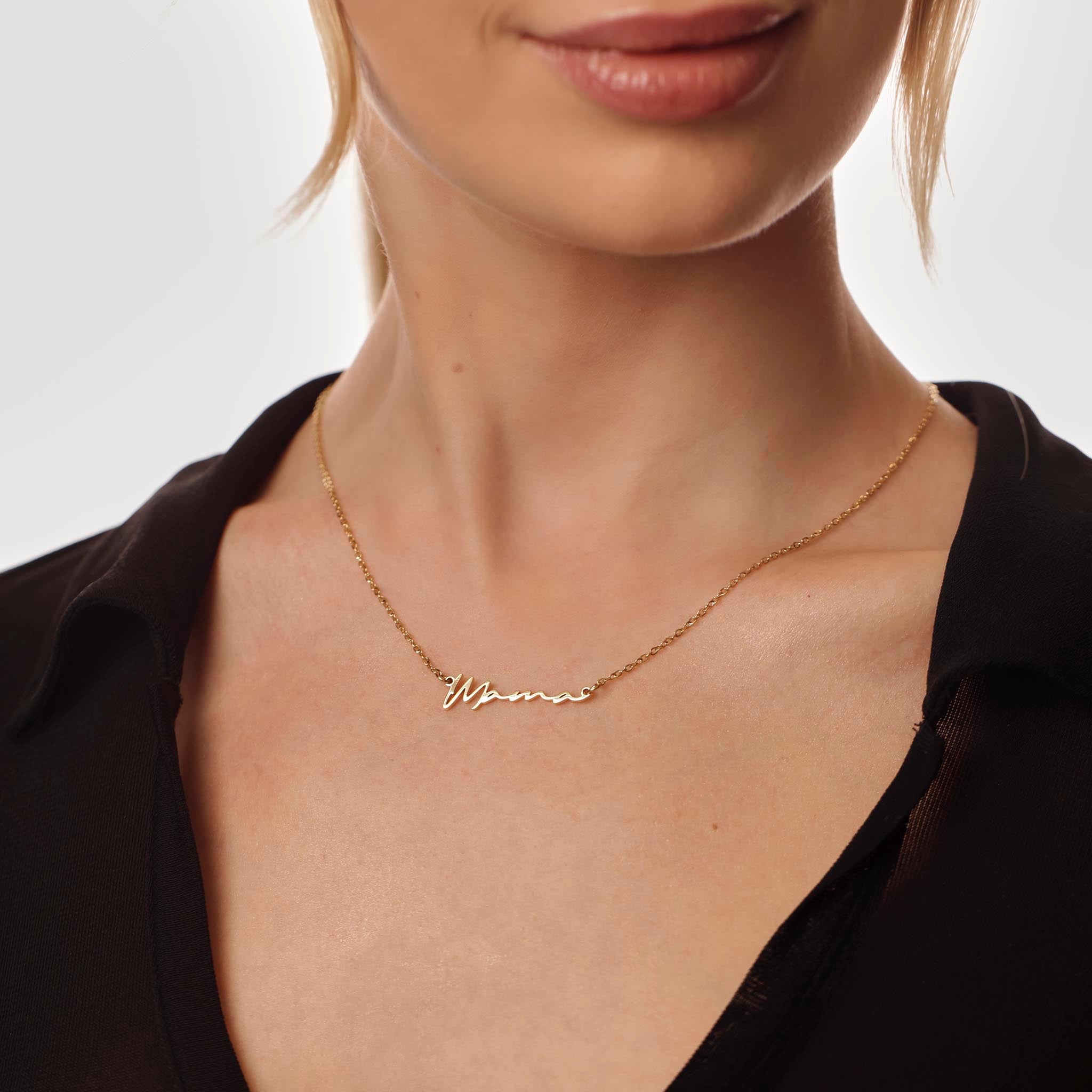 Gold necklace with 'Mama' engraving on a person wearing a black top.