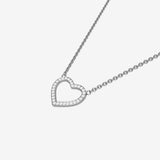 Heart-shaped silver necklace with small diamonds on a light gray background