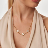 Necklace with clover gold necklace worn by a person in a beige outfit