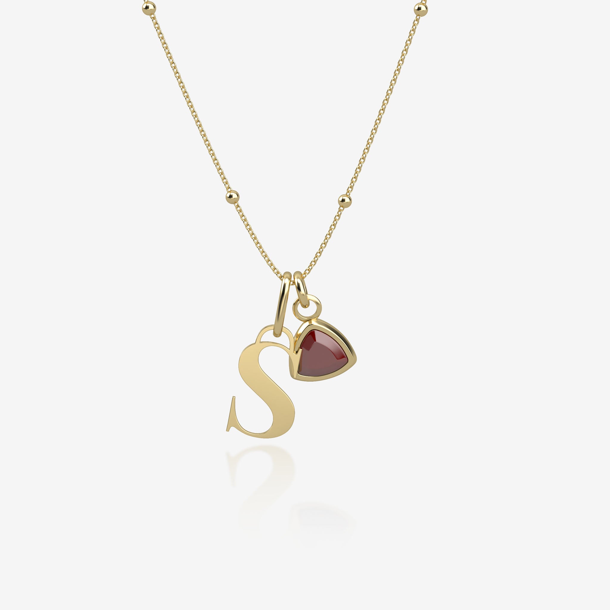 gold necklace with 'S' pendant and birthstone pendant on white background