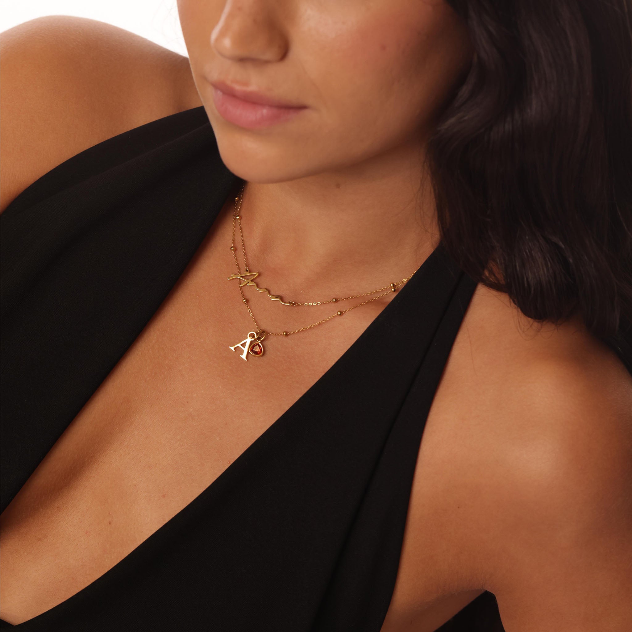 Close-up of a woman wearing a gold necklace with a pendant.