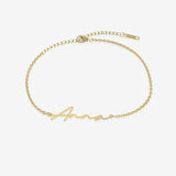 Gold name bracelet with 'Anna' engraving on a white background