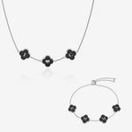 Silver and black clover name necklace and bracelet set on white background