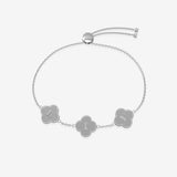 Silver bracelet with clover-shaped charms displaying initials on a light gray background