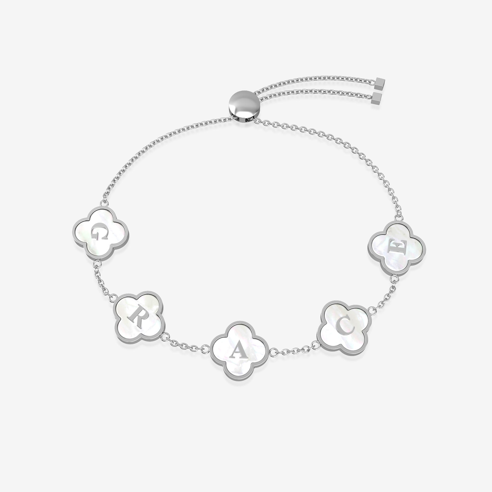 Silver bracelet with clover-shaped charms displaying letters on a white background