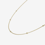 Gold necklace on a light beige background