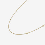 Gold necklace on a light beige background