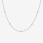 Silver ball chain necklace on a light gray background