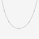 Silver ball chain necklace on a light gray background