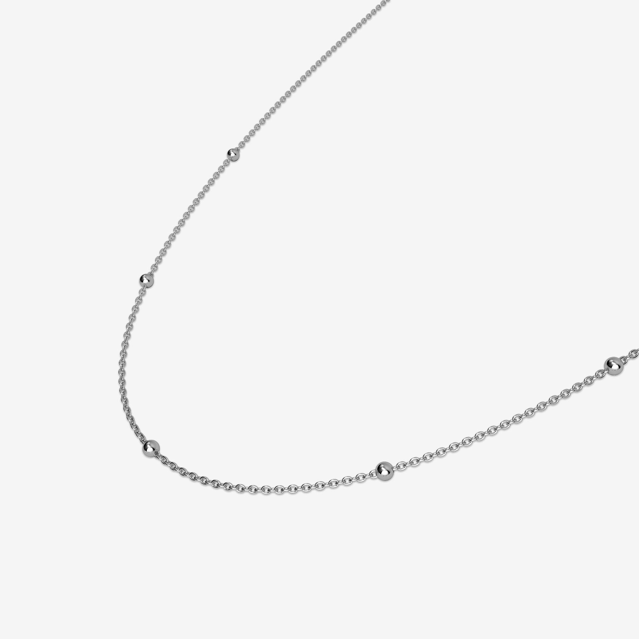 Silver ball necklace chain on a light gray background